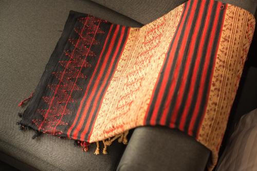 a red and white striped tie sitting on a chair at Soravit on Granville in Hong Kong