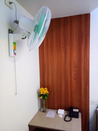 a room with a table with flowers and a fan at Anthurium Inn in Mactan