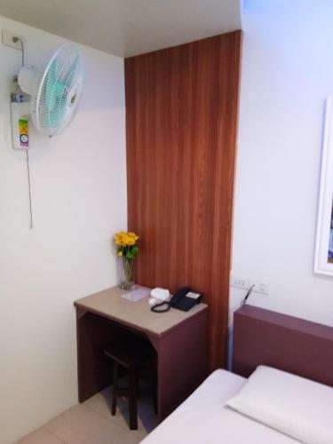 a small room with a desk and a fan at Anthurium Inn in Mactan
