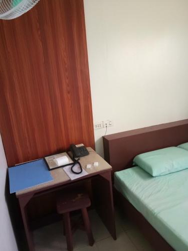 a room with a desk with a bed and a deskablish at Anthurium Inn in Mactan
