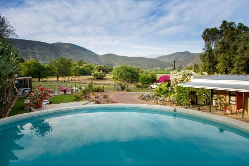 a pool with a view of the mountains at Die Fonteine Country Guesthouse and Glamping in Oudtshoorn