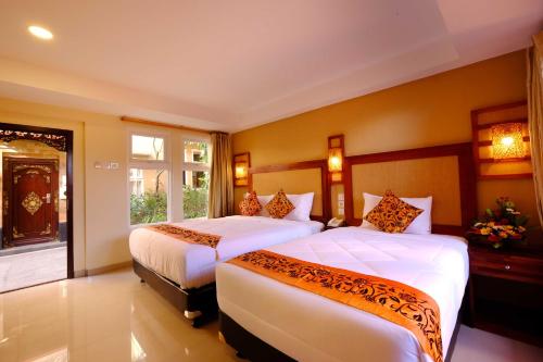 a hotel room with two beds and a window at Sari Villa Ubud in Ubud