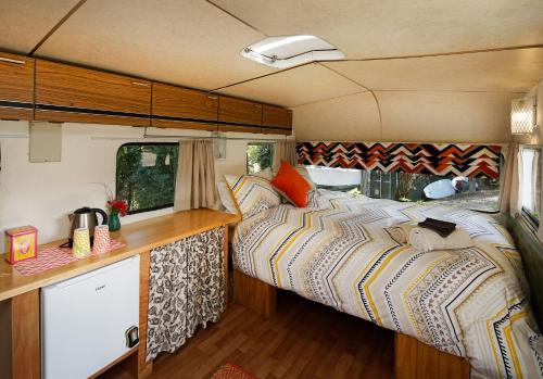 a bedroom with two beds in a caravan at Wai-knot Accommodation in Onetangi