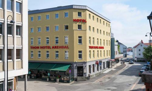 a tall yellow building with a hotel on it on a street at Thon Hotel Arendal in Arendal