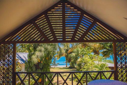 um quarto com vista para a praia e palmeiras em Coconuts em Grand Baie