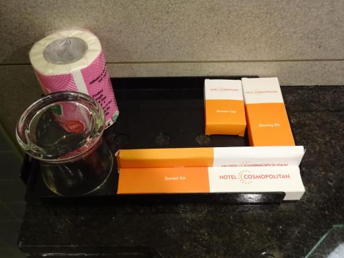 a table with a glass of wine and a candle at Hotel Cosmopolitan in Ahmedabad