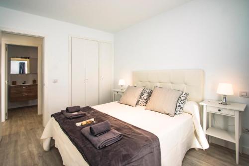プラヤ・オンダにあるFlower Beach Suite 7のベッドルーム1室(大きな白いベッド1台、タオル付)