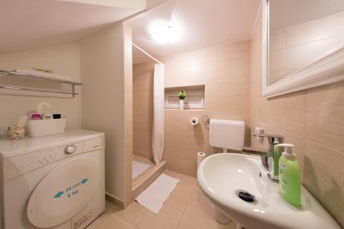 a bathroom with a toilet and a sink at Apartmani "Mimoza" in Otočac