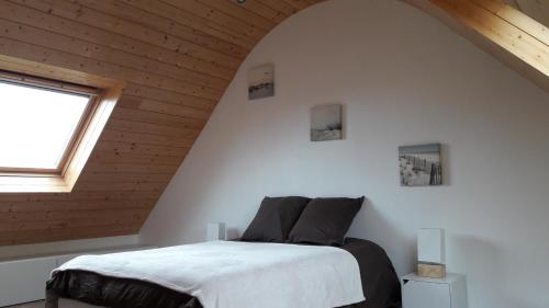Lampaul-PlouarzelにあるVilla Lampaulのベッドルーム1室(屋根裏部屋に大型ベッド1台付)