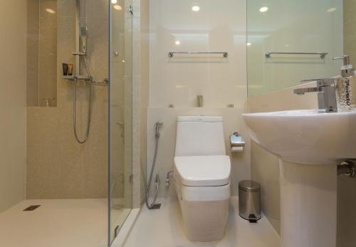 Un baño con inodoro, lavabo y ducha. en The Aristo by Holy Cow, 2-BR loft, 90 m2, pool view, en Surin Beach