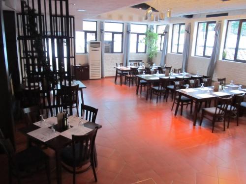 a dining room with tables and chairs and windows at Persey Flora Apartments in Borovets