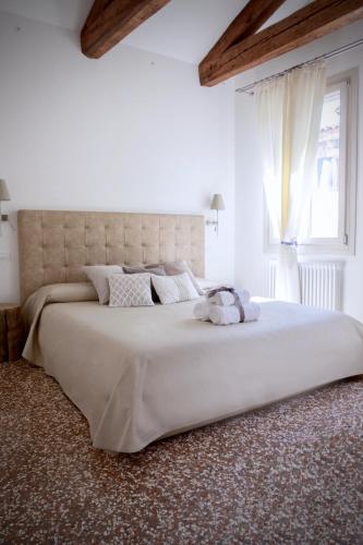 a large white bed in a white room with a window at B&B Al Pozzo di Luce in Venice