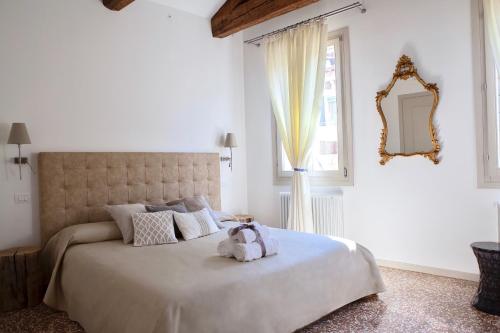 um quarto com uma cama grande e um bicho de peluche. em B&B Al Pozzo di Luce em Veneza