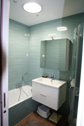 a bathroom with a sink and a tub and a mirror at villa avec jacuzzi in Sainte-Maxime