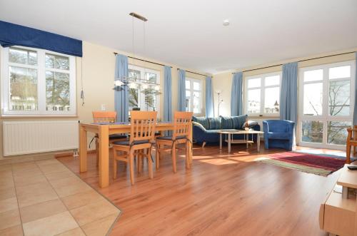 ein Wohnzimmer mit einem Tisch, Stühlen und einem Sofa in der Unterkunft Villa Seerose - Appartement 05 in Ostseebad Sellin