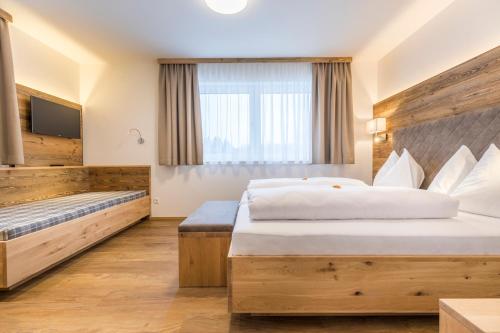 a hotel room with a bed and a tv at OFENTÜRL alpine living in Flachau