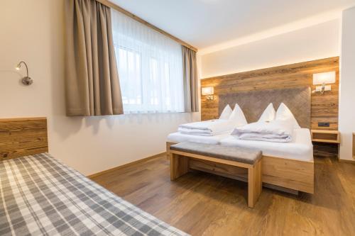 a hotel room with two beds and a window at OFENTÜRL alpine living in Flachau