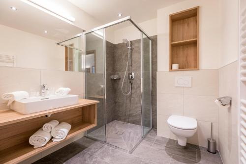 een badkamer met een douche, een toilet en een wastafel bij OFENTÜRL alpine living in Flachau
