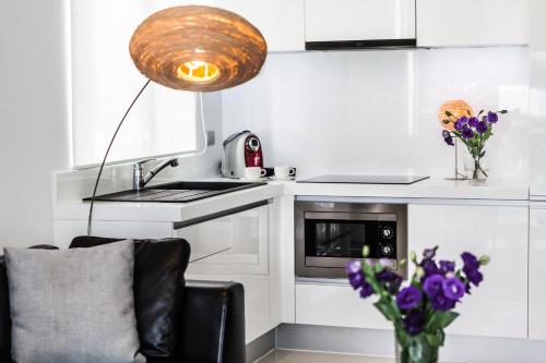 a kitchen with a vase of purple flowers and a lamp at BYD Lofts - Boutique Hotel & Serviced Apartments - Patong Beach, Phuket in Patong Beach