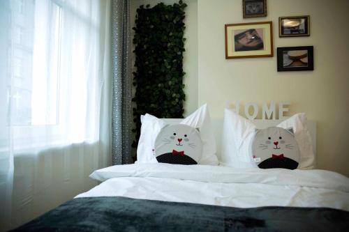 クラクフにあるAmazing Apartment, City Centre, Modern, Elegant, Cozyのベッドの上に座る白猫枕2つ