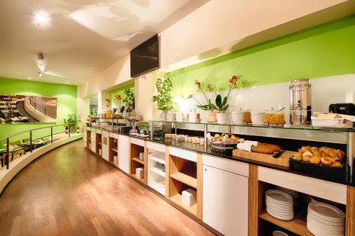 a restaurant with green walls and a counter with food at Leonardo Boutique Hotel Rigihof Zurich in Zurich