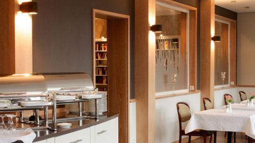 a restaurant with two tables and a counter with dishes at Akzent Hotel Dorn in Büsum