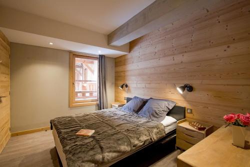ラルプ・デュエズにあるOdalys Chalet Nuance de grisの木製の壁のベッドルーム1室(ベッド1台付)