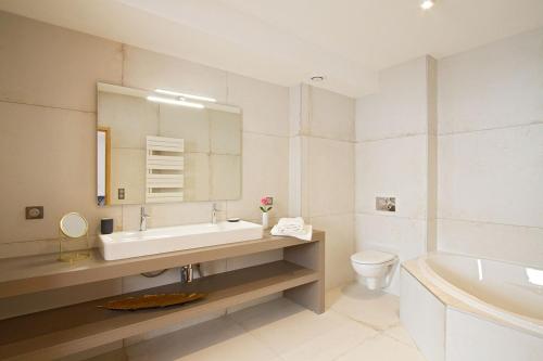 ラルプ・デュエズにあるOdalys Chalet Nuance de grisのバスルーム(洗面台、トイレ、バスタブ付)