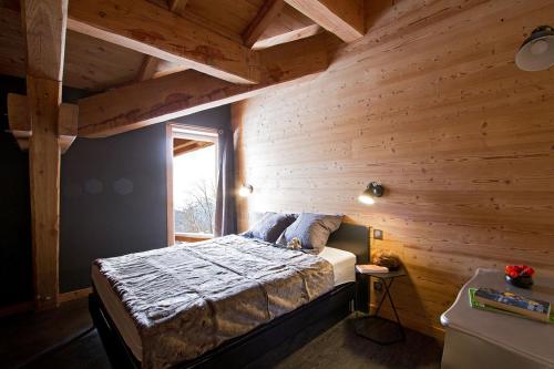ラルプ・デュエズにあるOdalys Chalet Nuance de bleuの木製の壁のベッドルーム1室