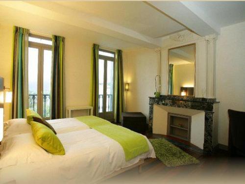 - une chambre avec un lit, une cheminée et un miroir dans l'établissement Maison de l'Esplanade, à Saint-Gaudens