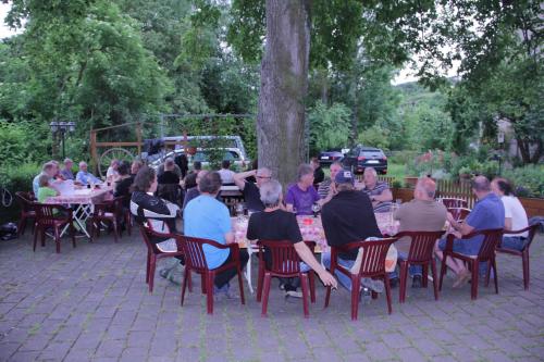 a group of people sitting at tables in a garden at Gasthof Linde-Classico in Bad Mergentheim