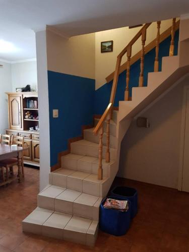 a staircase in a living room with a blue wall at Отель "Natali" in Mykolaiv