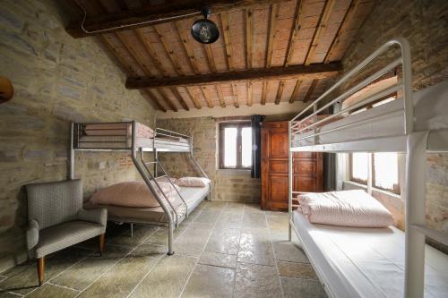 TredozioにあるCasalino di Sopraの二段ベッド2台と椅子が備わる客室です。