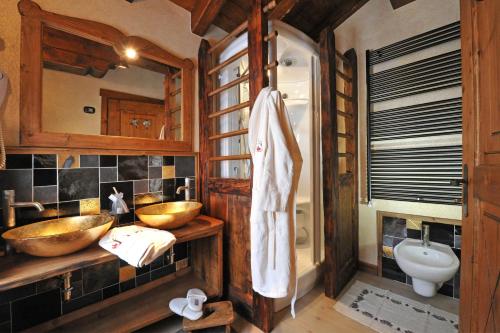 La salle de bains est pourvue de 2 lavabos en bois et de toilettes. dans l'établissement Affittacamere Petit Coeur, à Champoluc