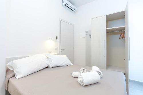 a white bedroom with a bed with towels on it at Hotel Tourist Meuble in Rimini