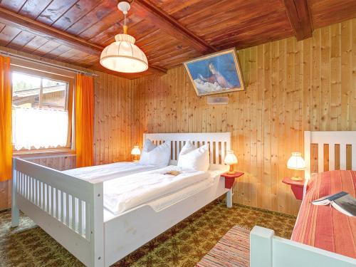 ハイリゲンブルートにあるFerienhaus mit Kaminofen A 650.014の木製の壁のベッドルーム1室(白いベッド1台付)