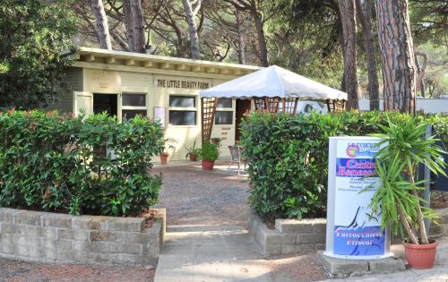 a small building with a sign in front of it at Le Esperidi Camping Ecoresort in Marina di Bibbona