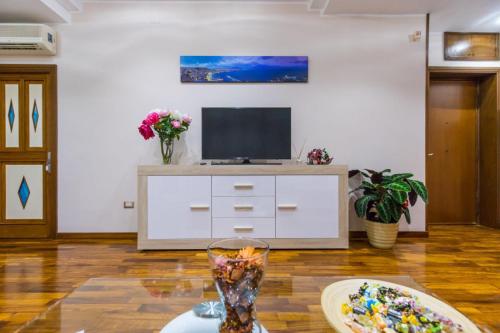 a living room with a tv and a table at B&b Il miglio d’oro in Ercolano
