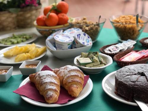 una mesa cubierta con platos de comida con repostería y postres en Villa Cristina, en Siracusa