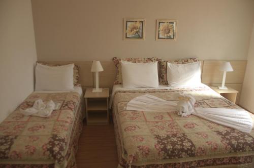亚瓜龙Crigial Hotel的在酒店房间设有两张床,里面装满了动物