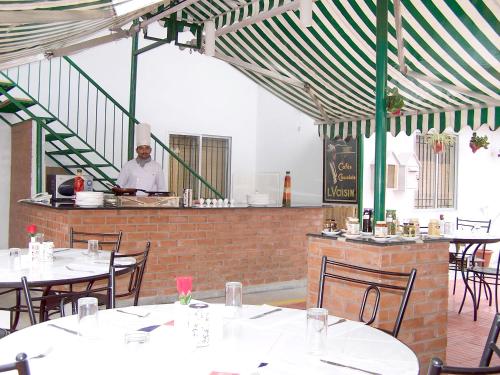 a restaurant with tables and a chef in the kitchen at Sterling Living Space - Residency Road in Bangalore