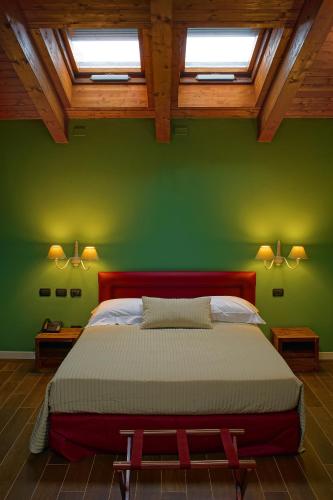 a bedroom with a large bed in a green wall at Agriturismo Il Boschetto in Ornago