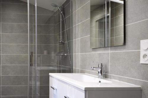 uma casa de banho com um lavatório e um chuveiro em Les pirondeaux em Rocamadour