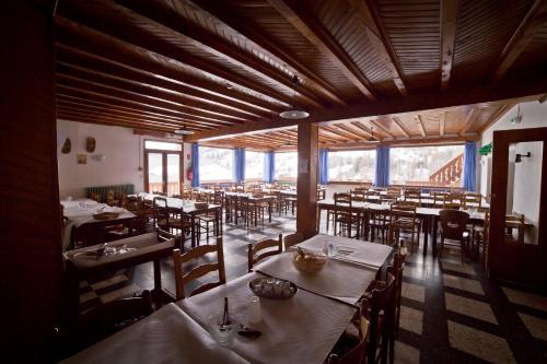un restaurant avec des tables et des chaises dans une salle dans l'établissement Centre de Vacances Le Val d'Escreins, à Vars