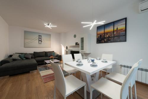 uma sala de estar com uma mesa branca e cadeiras em Grand Vitosha Apartments em Sófia