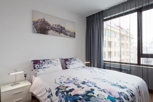 a bedroom with a bed and a large window at Grand Vitosha Apartments in Sofia