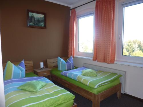 2 camas en una habitación con 2 ventanas en Pension Märkische Bauernstube, en Schorfheide