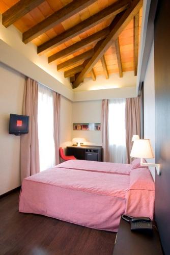 a bedroom with a pink bed in a room at Hotel El Raset in Denia