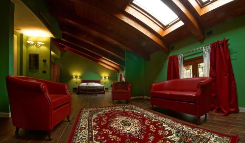 a bedroom with red chairs and a bed and a window at Agriturismo Il Boschetto in Ornago