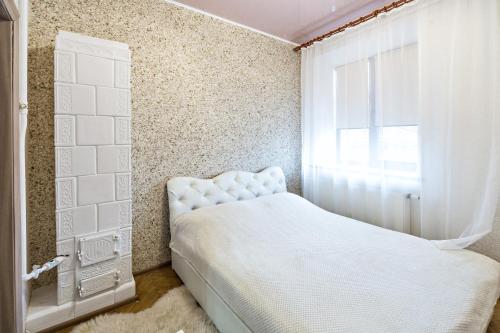 um quarto com uma cama branca e uma janela em Apartment in a city center! Krakivska,34 em Lviv